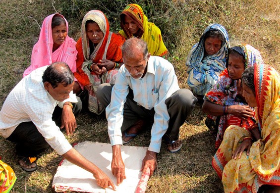 Women with government officials showing their new land plots